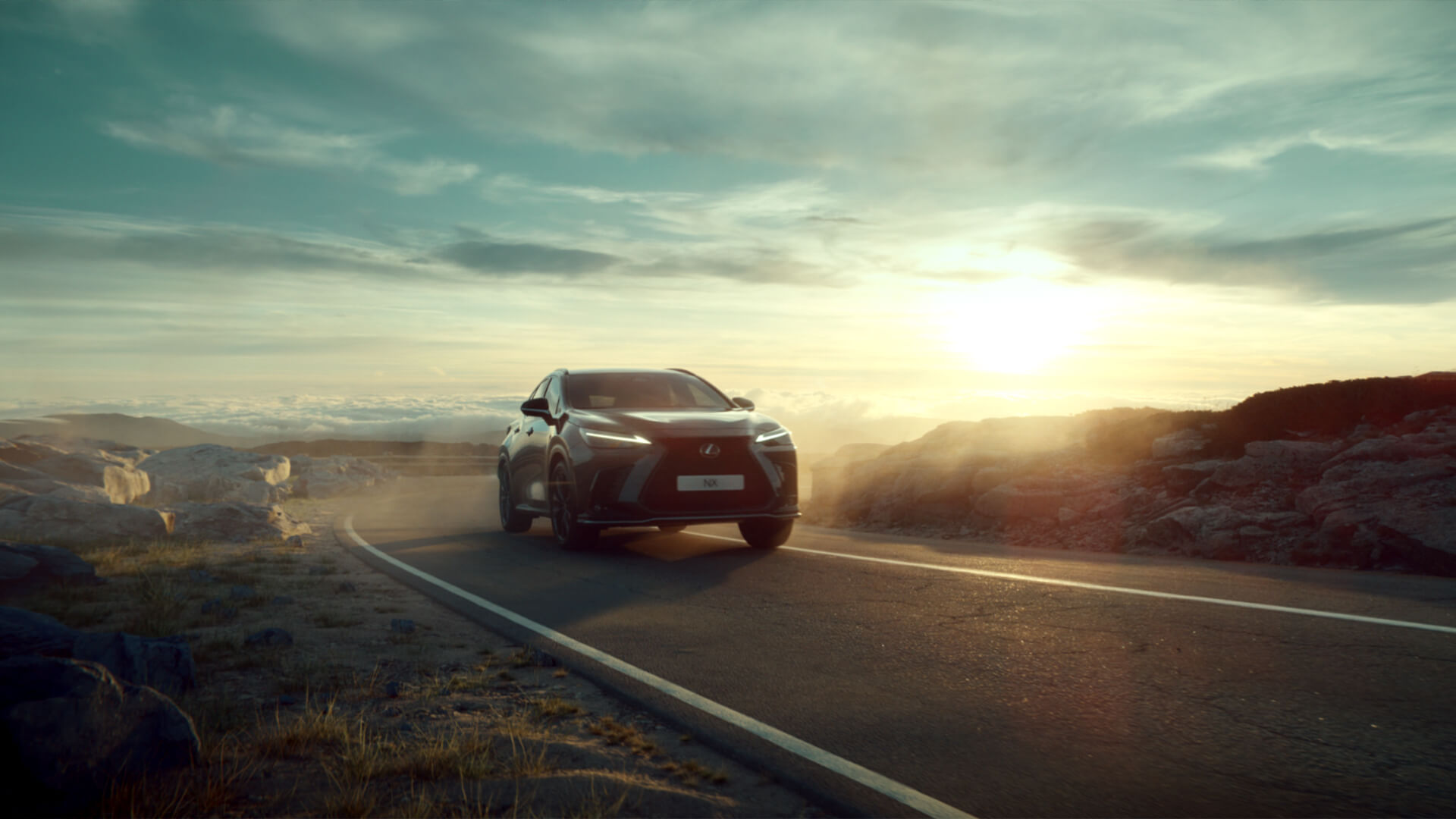 Grey Lexus NX being driven on a winding open road.