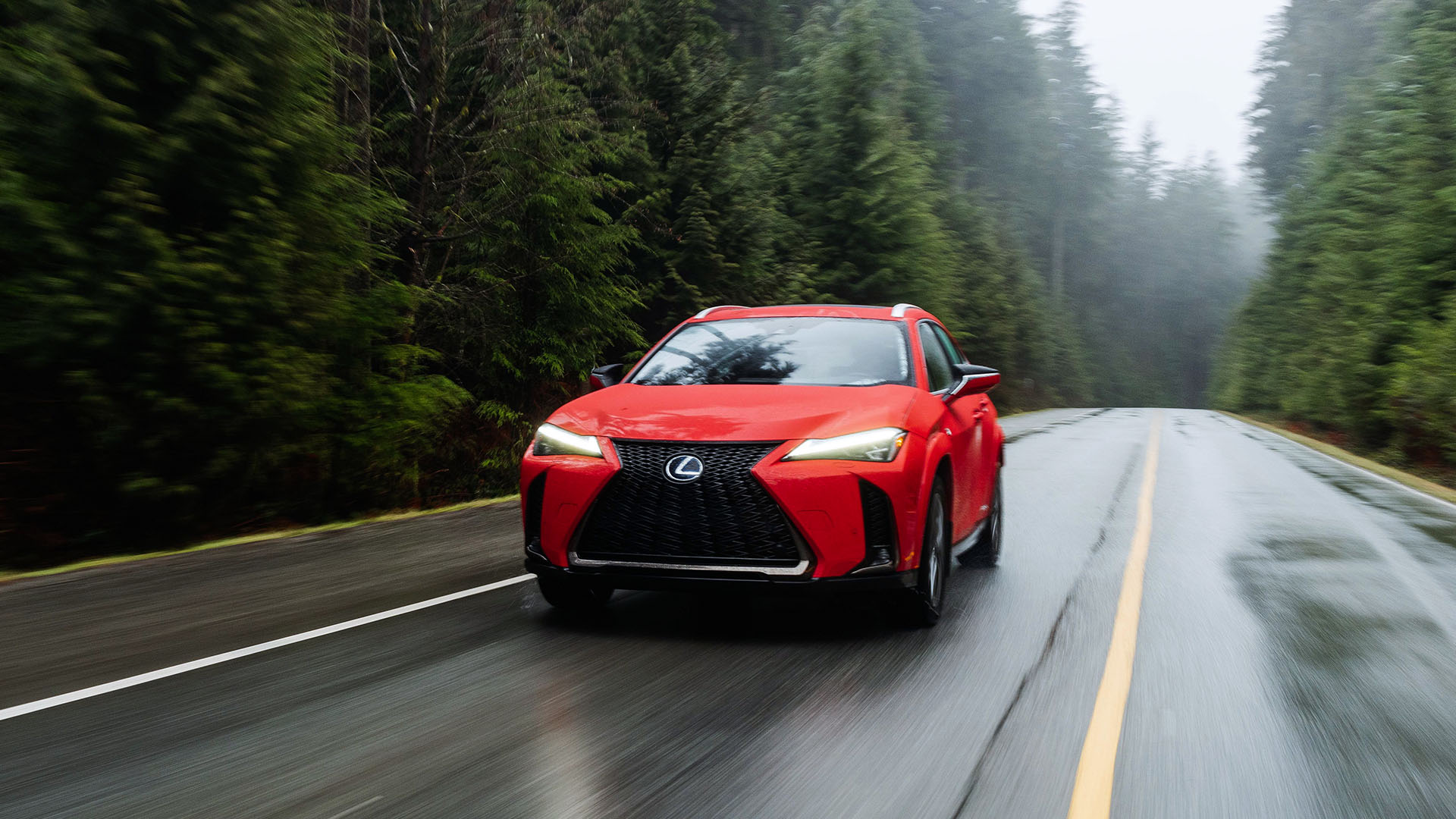 Lexus UX 250h in a carpark with its headlights switched on.