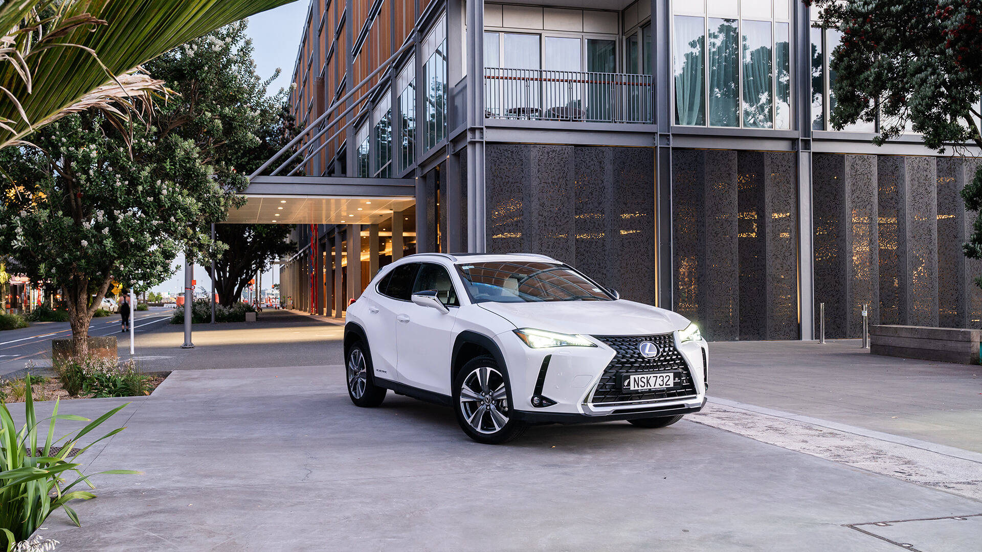White Lexus UX parked near a city building.